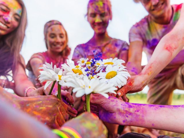 cropped-shot-of-young-friends-holding-chamomiles-at-holi-festival.jpg